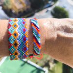 Dos pulseras artesanales de chaquiras Miyuki en tonos vibrantes sobre la muñeca.